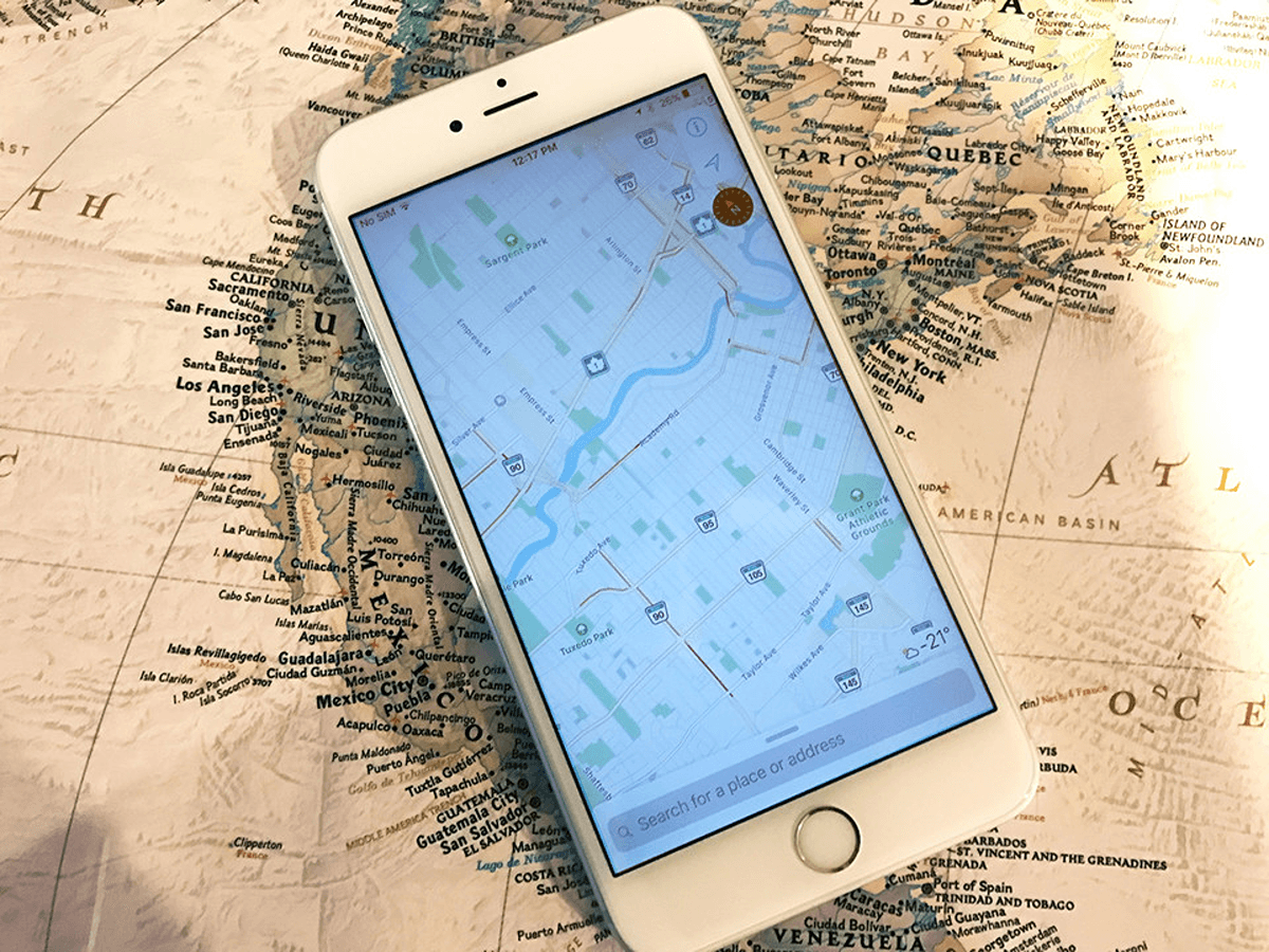 Un smartphone affichant l’application de cartographie sur une carte papier d’aspect ancien