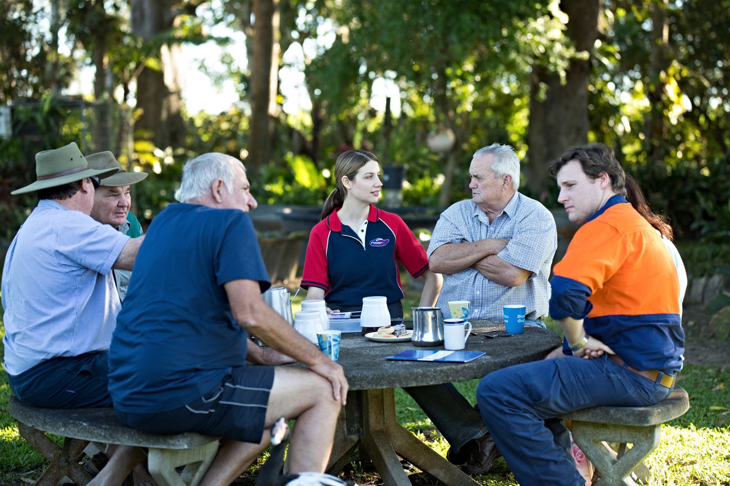 Una persona de Powerlink está sentada alrededor de una mesa con miembros de la comunidad local
