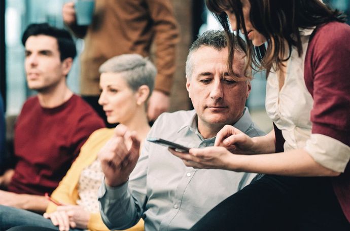 Dos personas mirando un dispositivo juntas