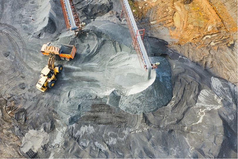 Un site minier vu du ciel, avec un camion minier et des infrastructures visibles
