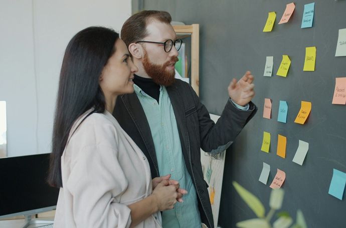 Personas mirando notas adhesivas juntas
