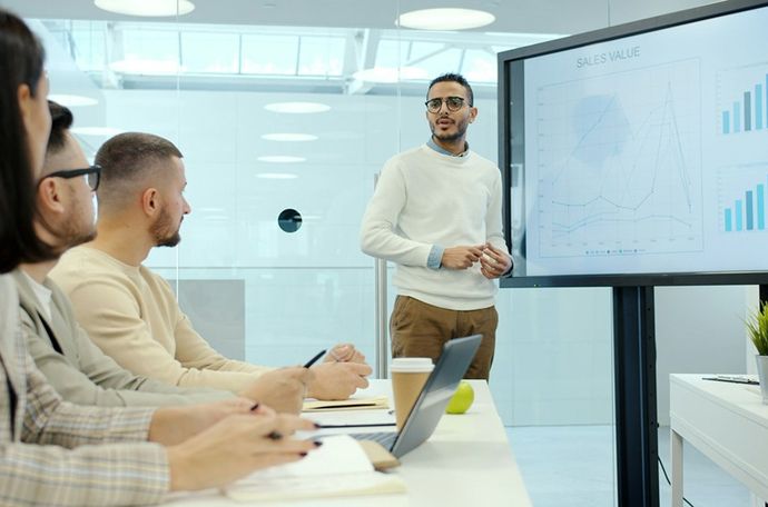 Persona presentando datos a un grupo de personas